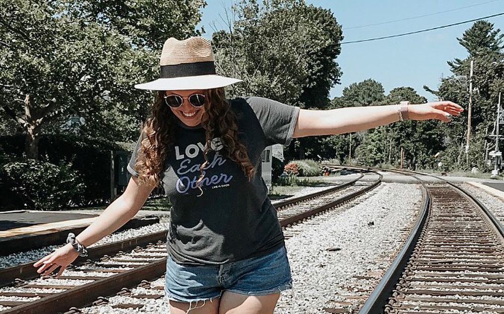 New-Molly-McCarthy-Blog_TrainTracks young woman balancing on train tracks smiling