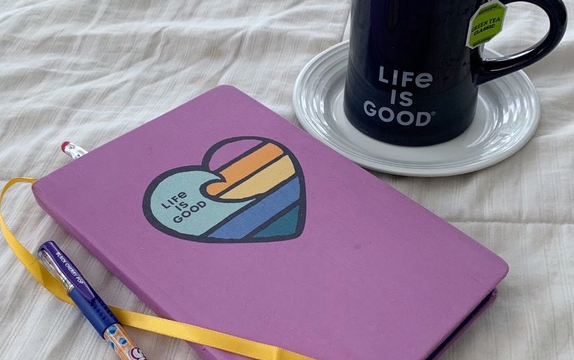 life is good journal, pen and cup of coffee in bed
